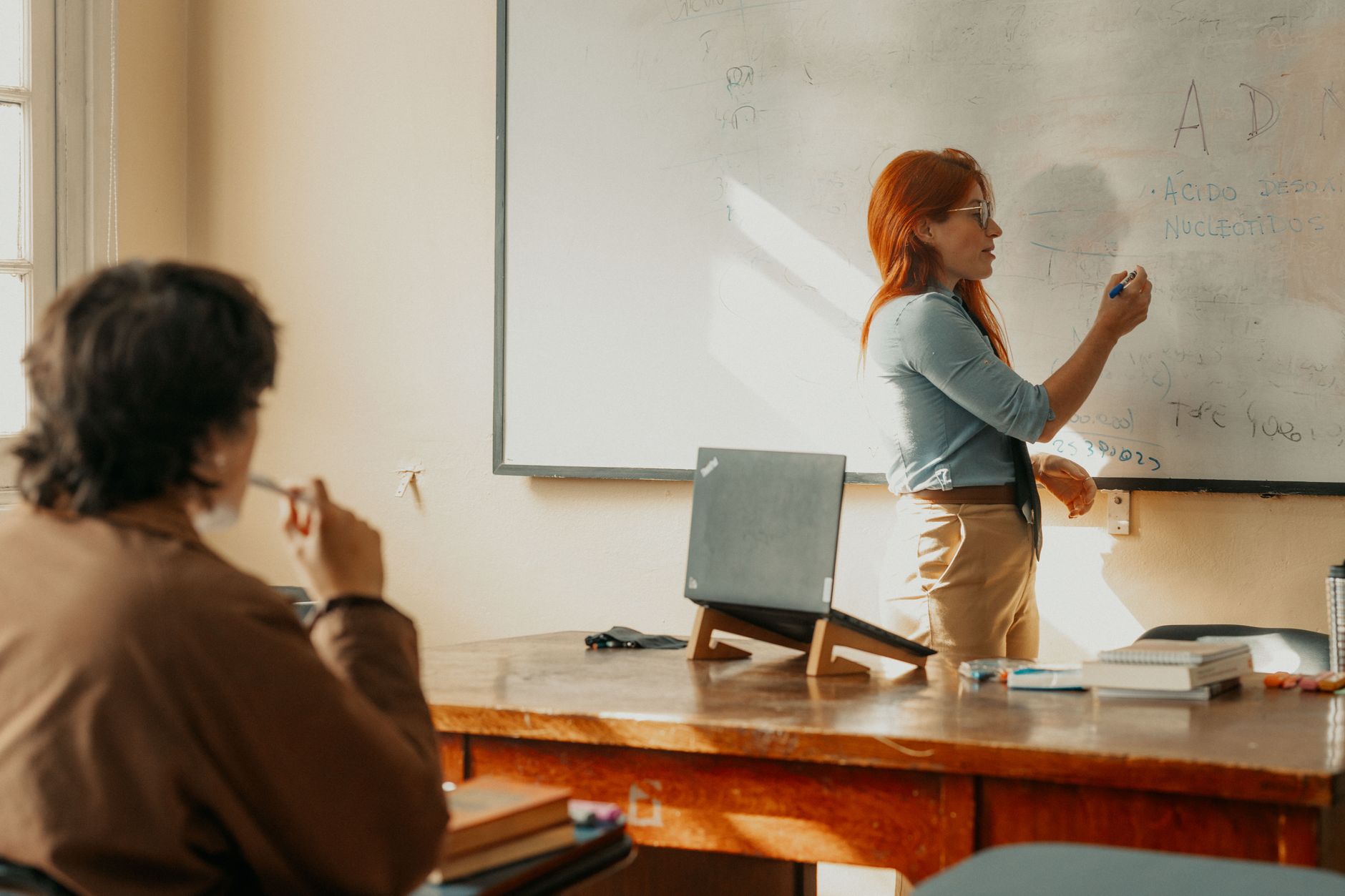 Instructor teaching a student in a Buenos Aires classroom with a whiteboard.