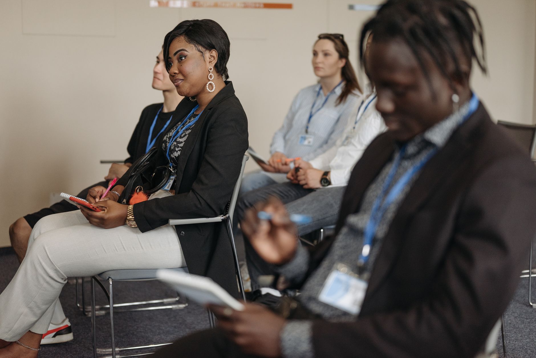 Attendees engaged in a lively business conference session, taking notes and listening attentively.